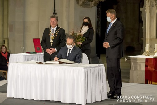Auch der Außenminister Maas trägt sich ins Goldene Buch der Stadt Magdeburg ein.